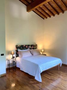 a bedroom with a large white bed with two tables at Appartamento in villa storica: Villa Giulia in Empoli
