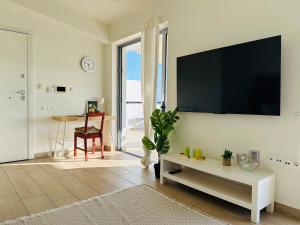 a living room with a large flat screen tv on a wall at Top-Floor 2BR Penthouse with Stunning Sea View in Athens