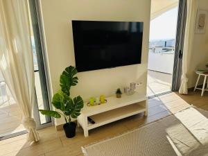 a living room with a flat screen tv on a wall at Top-Floor 2BR Penthouse with Stunning Sea View in Athens