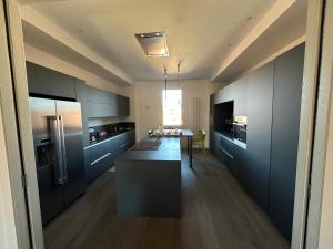 a kitchen with black cabinets and a table in it at The Loft in Castel San Pietro Terme +6 photos