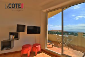 een kamer met balkon met tv en twee krukken bij Ciel et mer in Sausset-les-Pins