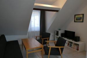 a living room with a table and chairs and a television at Trappe's Maar-Häuschen in Ulmen