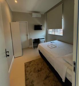 une chambre avec un grand lit et une fenêtre dans l'établissement Hotel Corporativo Paragominas, à Paragominas