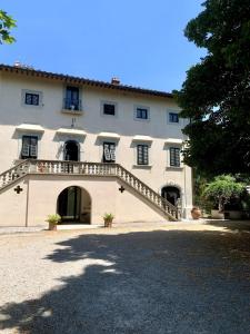 a large building with a staircase leading up to it at Appartamento in villa storica: Villa Giulia in Empoli +26 photos