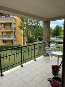 a balcony with a table and a bench and a building at Büki Villa Park Apartman in Bük