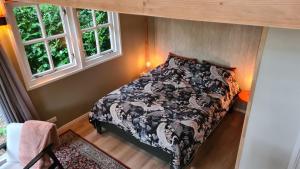 a bedroom with a bed in a room with two windows at B&B De Vretberg in Enschede