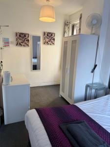 a bedroom with a bed and a cabinet and a mirror at The Hotel Blackpool in Blackpool