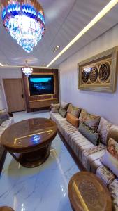a living room with a large couch and a table at شقة مينا روسيتا in Nador