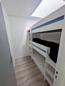 a bedroom with two bunk beds and a window at La Cahute des Tamaris in Mimizan-Plage
