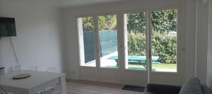 a living room with a sliding glass door with a table at La Cahute des Tamaris in Mimizan-Plage