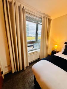 a hotel room with a bed and a window at Harbour Horizons in Edinburgh