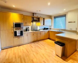 a kitchen with stainless steel appliances and wooden cabinets at Harbour Horizons in Edinburgh