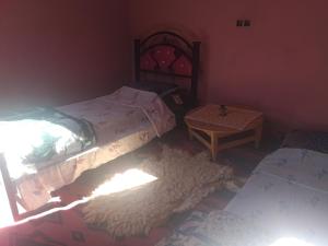 MhamidにあるBivouac beauté du désertのベッドルーム1室(ツインベッド2台、テーブル付)