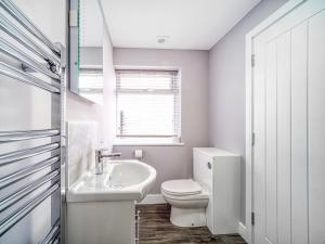 Un baño blanco con inodoro y lavabo. en Apartment 1 The Boardwalk - Uk31781, en Great Yarmouth 9 fotos más