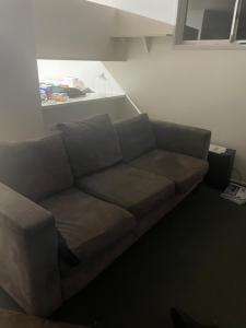 a living room with a couch in front of a refrigerator at scarborough QLD private accommodation in Scarborough
