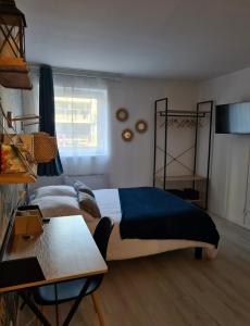 a bedroom with a bed and a table and a desk at Charmant studio, hypercentre de St Brieuc in Saint-Brieuc