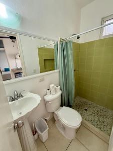 a bathroom with a toilet and a sink and a mirror at SelvaMar Estudios Playa in Playa del Carmen +22 photos