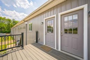 a house with a wooden deck with a door at Peaceful 4BR Barn Loft Escape in Grass Lake