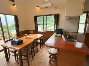 a kitchen with a wooden table and some chairs at 高井旅コテージ ログハウス - Takaitabi Cottage and LogHouse in Chiji
