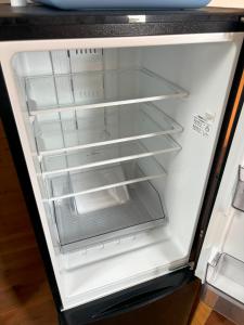an empty refrigerator with its door open at 高井旅コテージ ログハウス - Takaitabi Cottage and LogHouse in Chiji +41 photos