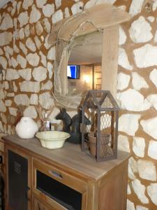 a counter with a mirror and a bird cage on it at Chez Isa Maison de pêcheur Etretat in Yport