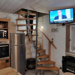 a living room with a staircase and a tv on a wall at Chez Isa Maison de pêcheur Etretat in Yport +15 photos