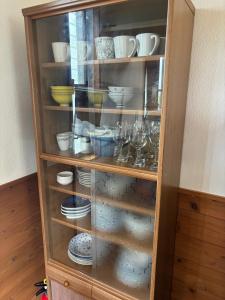 a cabinet filled with dishes and cups and glasses at 高井旅コテージ ログハウス - Takaitabi Cottage and LogHouse in Chiji