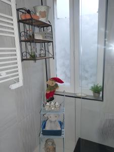 a shelf with a teddy bear on it in a room at Chez Isa Maison de pêcheur Etretat in Yport