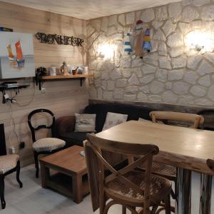a restaurant with a table and chairs and a stone wall at Chez Isa Maison de pêcheur Etretat in Yport