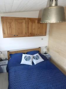 a bedroom with a blue bed with two pillows on it at Chez Isa Maison de pêcheur Etretat in Yport
