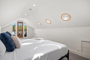 una camera da letto bianca con un letto bianco e una finestra di The Lokal 2 Kings Queen Suite in Sunnyside YYC a Calgary
