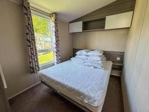 a small bedroom with a bed and a window at Stunning 8 Berth Caravan At Cherry Tree Holiday Park In Norfolk Ref 70711C in Great Yarmouth +15 photos