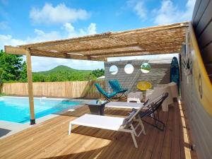 a wooden deck with chairs and a swimming pool at Villa Zandoli in Le Diamant