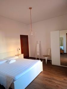 a bedroom with a large white bed and a mirror at Casa Mecenate in Arezzo