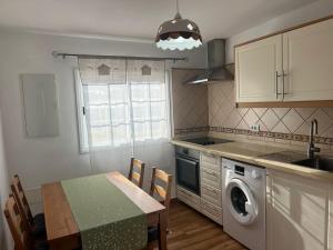 a kitchen with a table and a washing machine at Los Frailes in Breña Baja