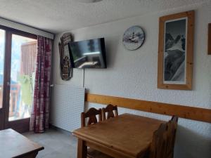 une salle à manger avec une table et une télévision murale dans l'établissement Studio avec garage privé au pied des pistes, Les Deux Alpes - FR-1-516-82, à Les Deux Alpes