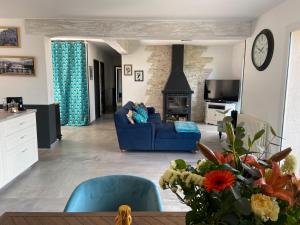 Una sala de estar con un sofá azul y una chimenea. en Villa paisible avec piscine privée, en Auribeau-sur-Siagne