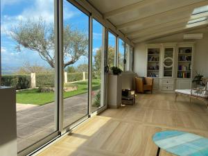 sala de estar con puertas correderas de cristal y mesa en Villa paisible avec piscine privée, en Auribeau-sur-Siagne