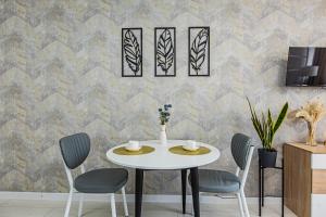a dining room with a table and chairs against a wall at BAYHOUSE - Апартаменты в ЖК Уш Сункар in Almaty