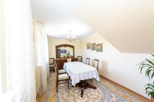 a dining room with a white table and chairs at Er Targyn 19 in Astana +10 photos