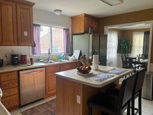a kitchen with a island with a bowl of fruit on it at Cozy Space in Central Location in Greendale +27 photos