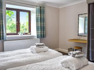 Un dormitorio con dos camas y una ventana. en The Granary - Uk47428, en Bewaldeth 4 fotos más