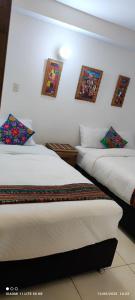 San AntonioにあるDepartamento en Recoleta - San Blasのベッドが2つあり、壁に絵が飾られている寝室