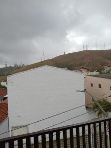 a white building with a hill in the background at Espaço nossa senhora aparecida a 4 min da basilica in Aparecida