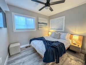 a bedroom with a bed with a ceiling fan and two windows at Urban Zen 2 - Luxury Remodel - Gr8 Deal- WOW in San Diego +29 photos