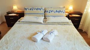 a pair of white slippers sitting on a bed at Apartment Lavanda in Fažana