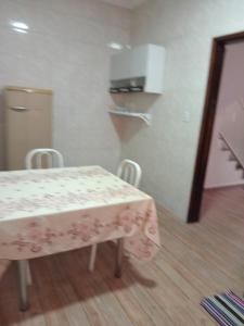 a room with a table and chairs and a kitchen at Espaço nossa senhora aparecida a 4 min da basilica in Aparecida