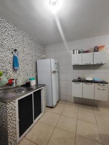 a kitchen with a white refrigerator in a room at Temporada Caminho de Búzios in Cabo Frio