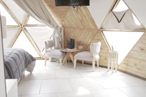 a bedroom with a bed and a table and chairs at Domos Los Molles in Los Molles