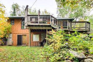 a house with a deck and a balcony at Sauna and Deck Wooded Cabin on Lake Vermilion! in Tower